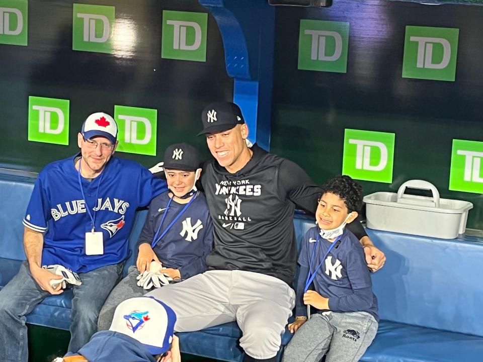 Aaron Judge takes a photo with young fan Derek Rodriguez, his younger brother and fellow fan Mike Lanzillotta before a game.