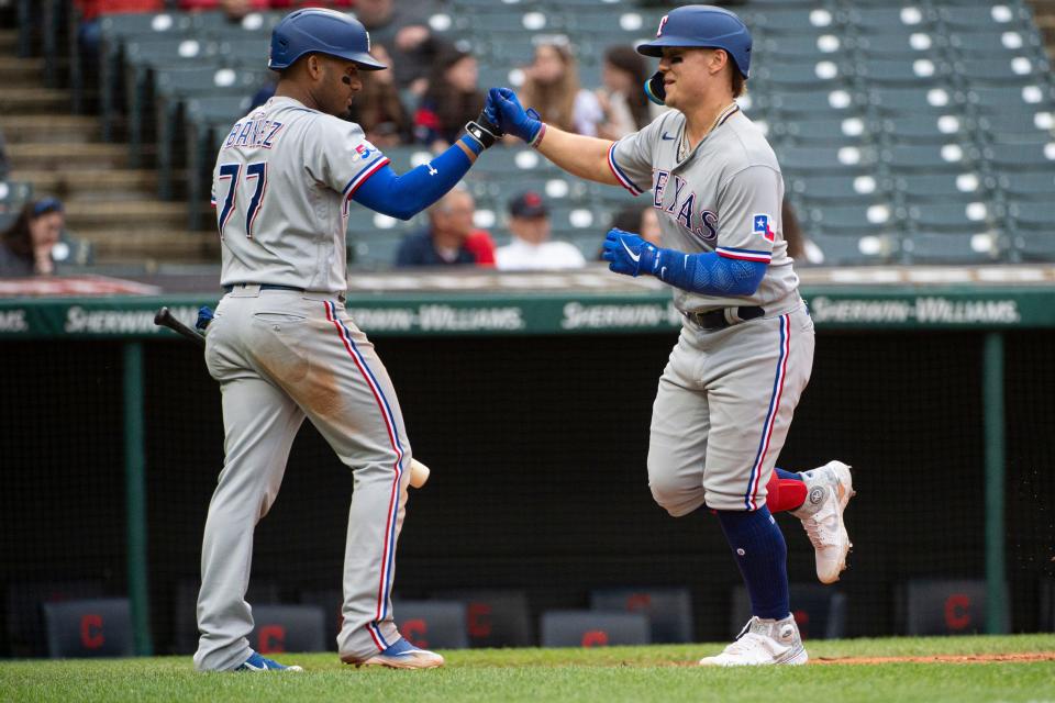 Texas Rangers' Texas Rangers' Steele Walker is greeted at home plate by Andy Ibanez after hitting a solo home run off Cleveland Guardians starting pitcher Cal Quantrill during the seventh inning of the first game of a baseball doubleheader in Cleveland, Tuesday, June 7, 2022. It was the first hit by Steele in the majors. (AP Photo/Phil Long)