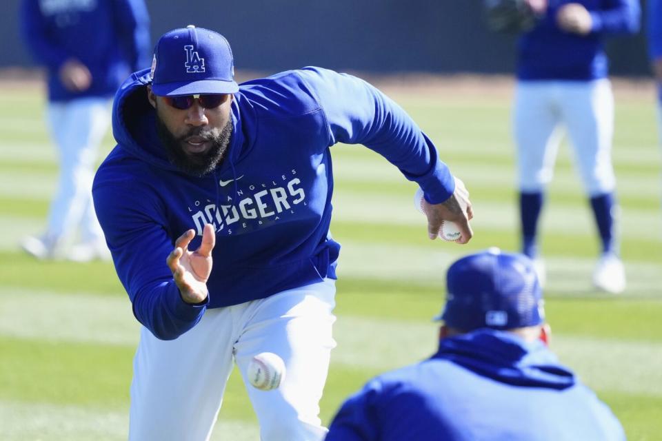 Dodgers outfielder Jason Heyward reaches for the ball during outfielder drills on Feb. 16, 2023.