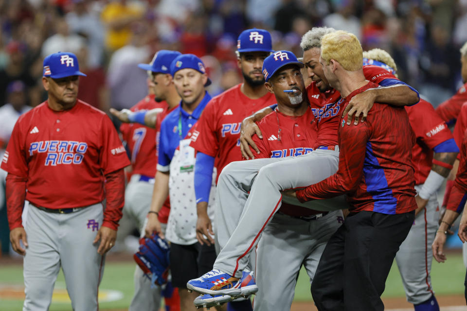 Mar 15, 2023; Miami, Florida, USA; Puerto Rico pitcher Edwin Diaz (39) gets taken off the field by pitching coach Ricky Bones (27) after an apparent leg injury during the team celebration against Dominican Republic at LoanDepot Park. Mandatory Credit: Sam Navarro-USA TODAY Sports