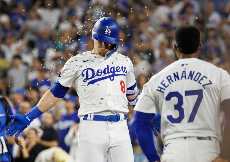 LOS ANGELES, CA - AUGUST 9, 2024: Los Angeles Dodgers third base Enrique Hernandez (8) gets hit with a sunflower seed shower form Los Angeles Dodgers outfielder Teoscar Hernandez (37) after hitting a two-run homer against the Pittsburgh Pirates in the fifth inning at Dodgers Stadium on August 9, 2024 in Los Angeles, California. (Gina Ferazzi / Los Angeles Times)