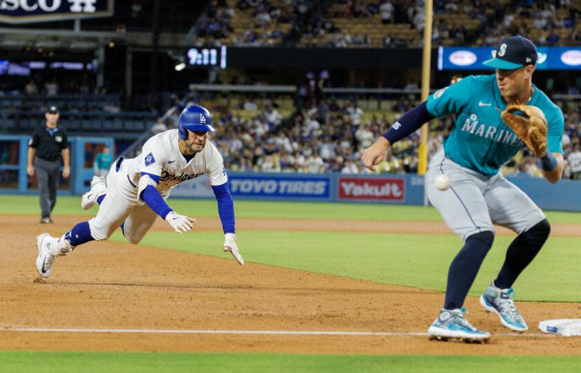 LOS ANGELS, CA - AUGUST 21, 2024: Los Angeles Dodgers outfielder Kevin Kiermaier (93) dives safely into third base as Seattle Mariners after hitting a triple as Seattle mariners third base Josh Rojas (4) receives the ball inside the baseline in the sixth inning at Dodgers Stadium on August 21, 2024 in Los Angeles, California. (Gina Ferazzi / Los Angeles Times)