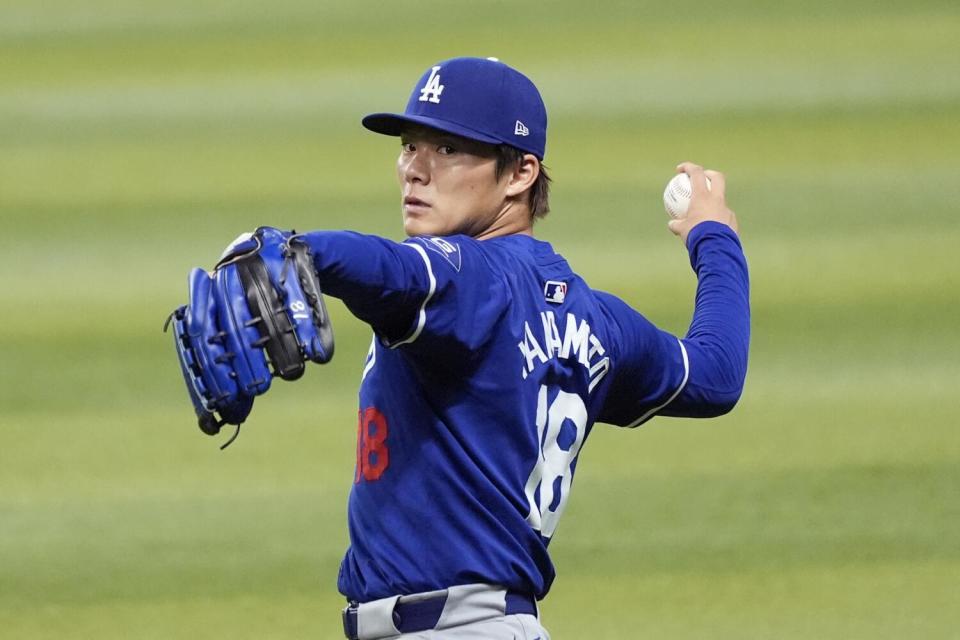 Injured Dodgers pitcher Yoshinobu Yamamoto tosses a ball before a game against the Diamondbacks on Sept. 1.