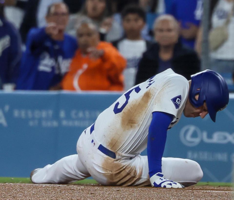 Freddie Freeman slowly gets up after turning his ankle while running to first base against the Padres on Thursday.