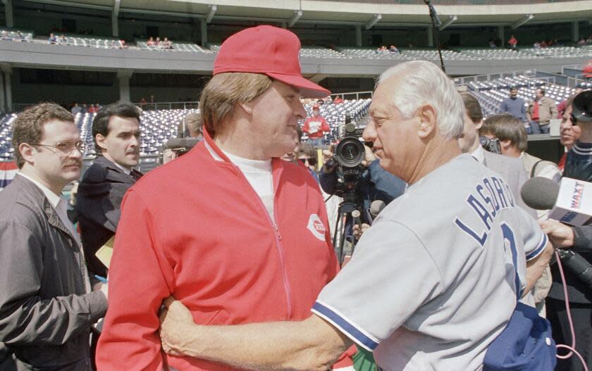 Cincinnati Reds manager Pete Rose and Los Angeles Dodger manager Tom Lasorda hug prior to the start of their National League opening game at Riverfront Stadium, Cincinnati, April 3, 1989. (AP Photo/Al Behrman)