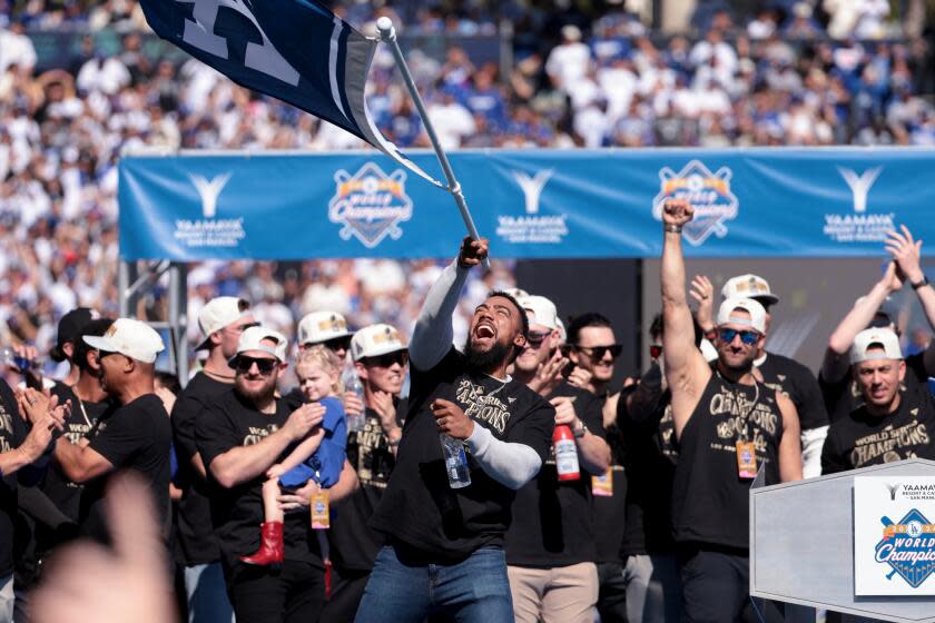 LOS ANGELES, CA - NOVEMBER 1, 2024: Dodgers Teoscar Hernandez waves a flag at the celebration at Dodgers Stadium. A victory parade celebrating the Dodgers' World Series title in Los Angeles, CA on Friday, November 1, 2024. (Wally Skalij/Los Angeles Times)
