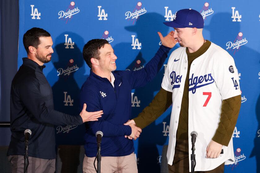 Los Angeles, CA - December 03: Blake Snell, right, shakes hands with president of baseball operations Andrew Friedman next to baseball executive Brandon Gomes, right, at an introductory press conference after the Dodgers signed the left-handed pitcher to a five-year, $182-million contract at Dodger Stadium on Tuesday, Dec. 3, 2024 in Los Angeles, CA. (Wally Skalij / Los Angeles Times)