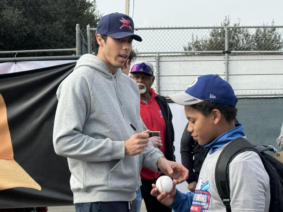 Christian Yelich of the Milwaukee Brewers signs autographs.