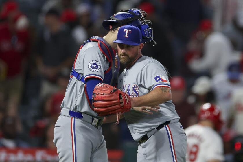 Texas Rangers relief pitcher Kirby Yates, right, and catcher Jonah Heim celebrate after the team's win in a baseball game against the Los Angeles Angels, Friday, Sept. 27, 2024, in Anaheim, Calif. (AP Photo/Ryan Sun)