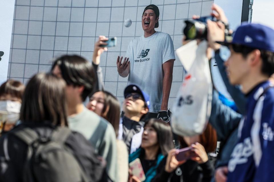 Fans stop for photos at the entrance plaza of the Tokyo Dome as they arrive to watch the Dodgers work out Friday.