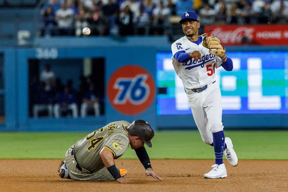 Dodgers shortstop Mookie Betts throws to first base after forcing out Padres baserunner Freddy Fermin at second on Aug. 15.
